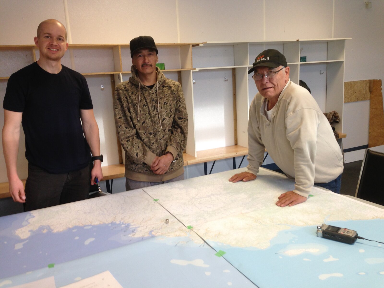 Community members and team gathered around a large territorial map